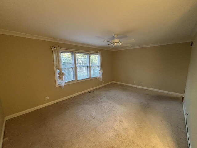 spare room featuring visible vents, baseboards, a ceiling fan, ornamental molding, and carpet