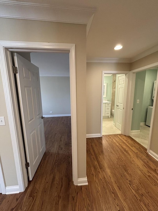 corridor featuring ornamental molding, recessed lighting, wood finished floors, and baseboards