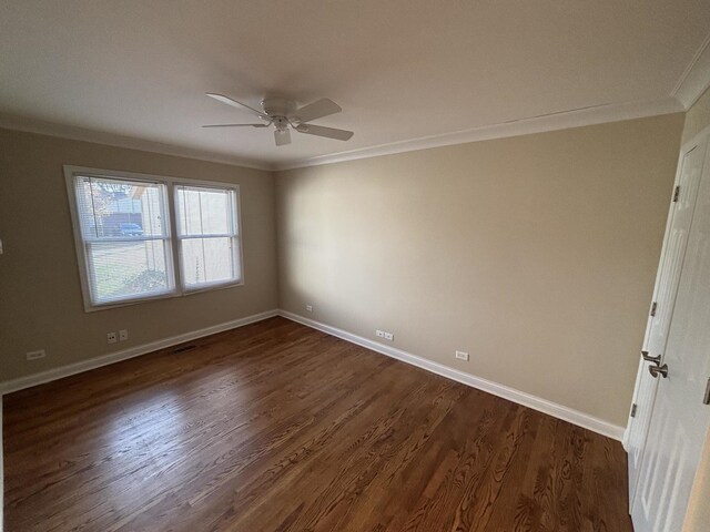 empty room featuring baseboards, dark wood-style flooring, visible vents, and crown molding