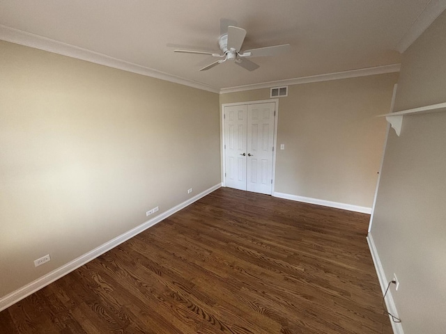 unfurnished bedroom featuring baseboards, visible vents, dark wood finished floors, and ornamental molding