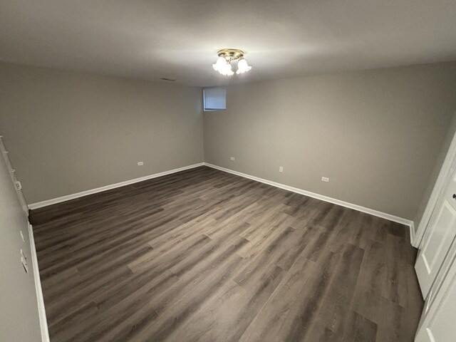 unfurnished room with dark wood-style flooring and baseboards