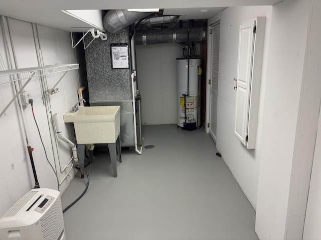 unfinished below grade area with gas water heater and a sink