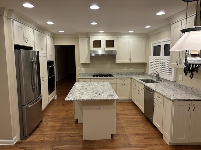 kitchen featuring dark wood-type flooring, a center island, stainless steel appliances, under cabinet range hood, and a sink