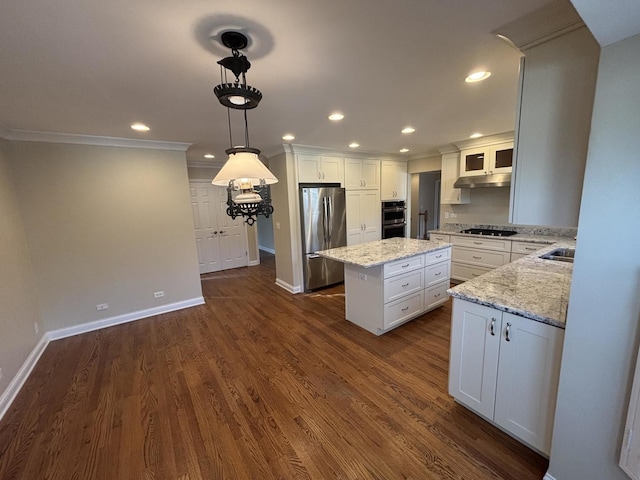 kitchen featuring under cabinet range hood, stainless steel appliances, white cabinets, a center island, and dark wood-style floors