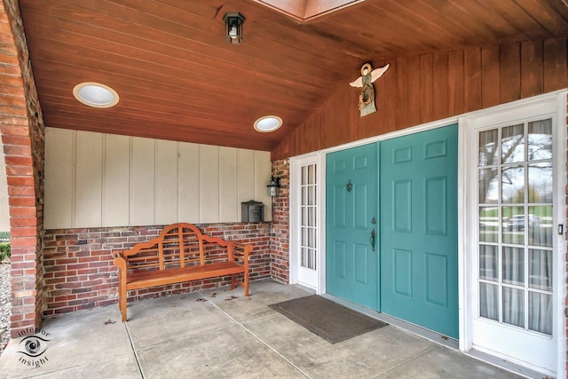 property entrance featuring covered porch and brick siding