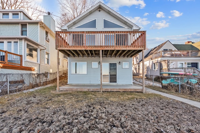 rear view of house with a patio area, fence, and a deck