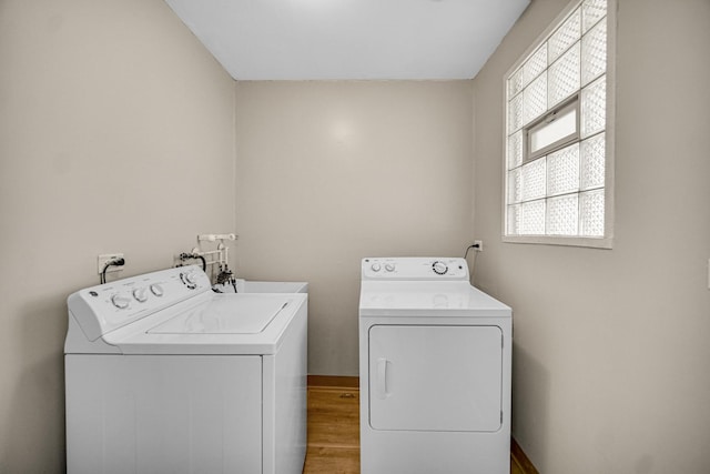 washroom with laundry area, baseboards, separate washer and dryer, and wood finished floors