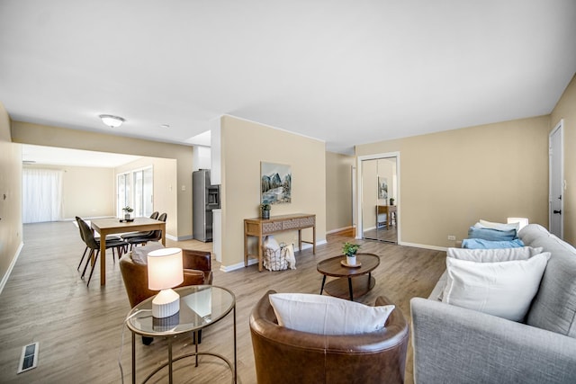 living area with light wood-style flooring and baseboards