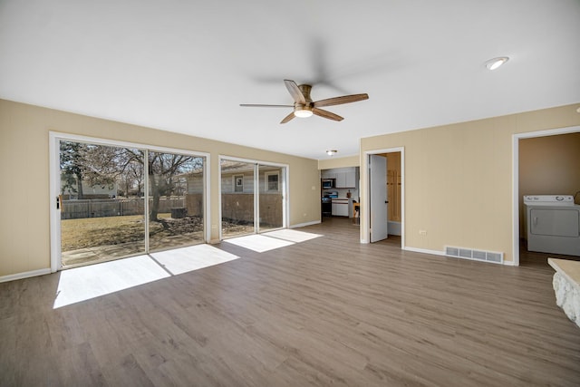 unfurnished living room with baseboards, ceiling fan, visible vents, and wood finished floors