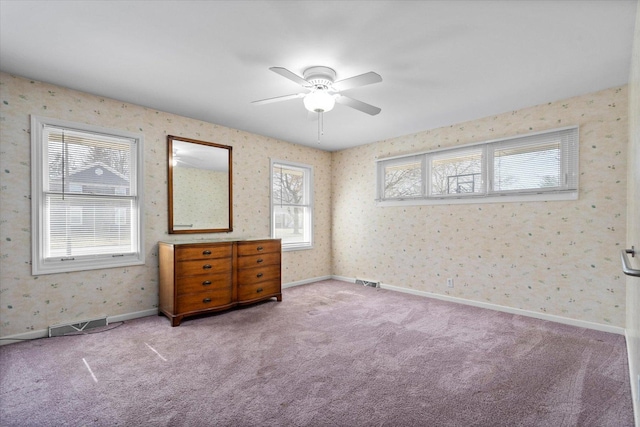 carpeted bedroom featuring visible vents, wallpapered walls, and baseboards