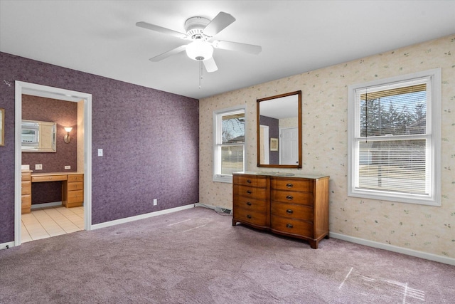 carpeted bedroom featuring connected bathroom, wallpapered walls, baseboards, and ceiling fan