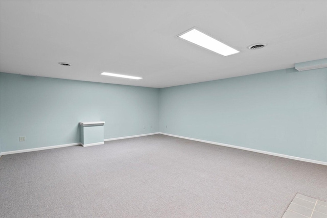 carpeted empty room featuring visible vents and baseboards