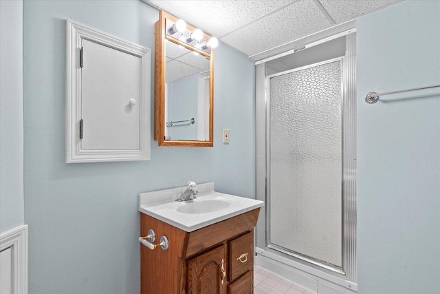 full bathroom with a shower stall, vanity, and a paneled ceiling