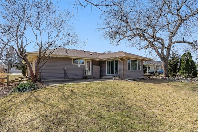 rear view of property with entry steps, a yard, and fence