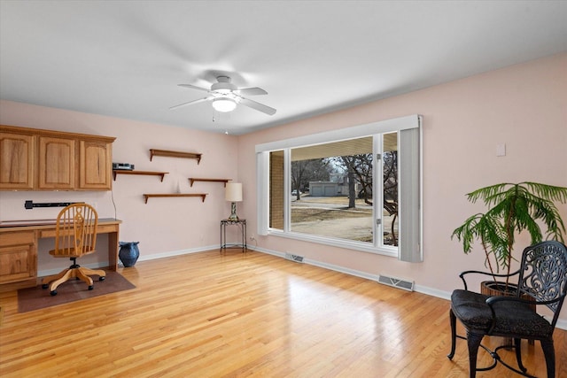 office featuring visible vents, baseboards, ceiling fan, and light wood finished floors