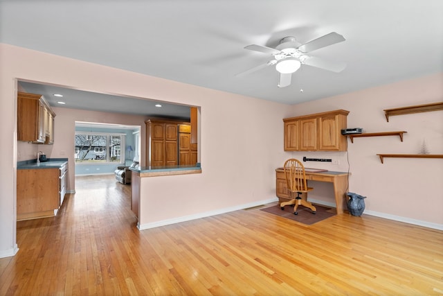 office space with baseboards, ceiling fan, recessed lighting, light wood-style flooring, and a sink