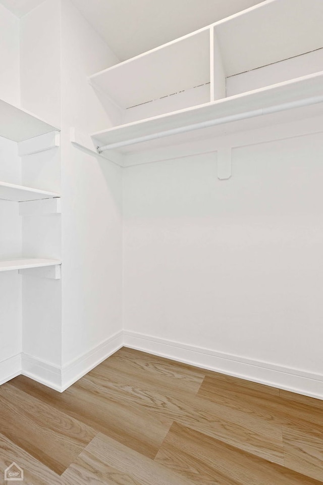 walk in closet with wood finished floors