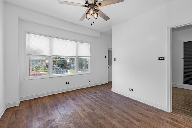 spare room with ceiling fan, wood finished floors, visible vents, and baseboards