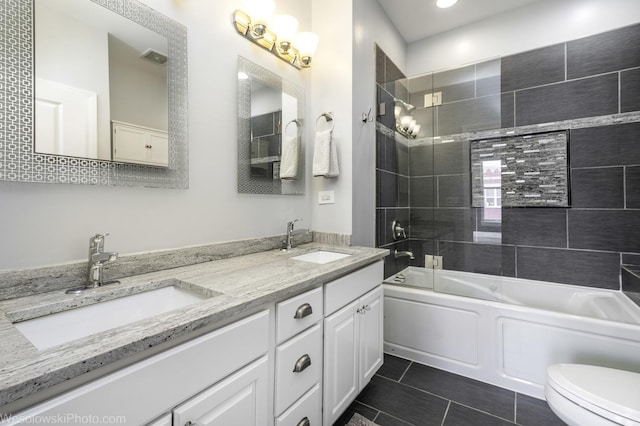 full bathroom featuring toilet, double vanity, bathtub / shower combination, and a sink