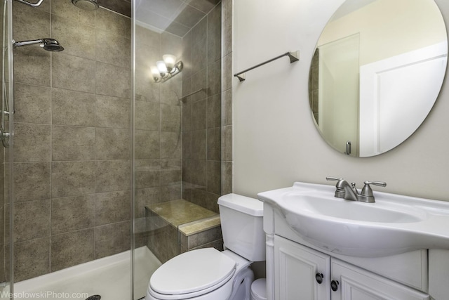 bathroom featuring toilet, a shower stall, and vanity