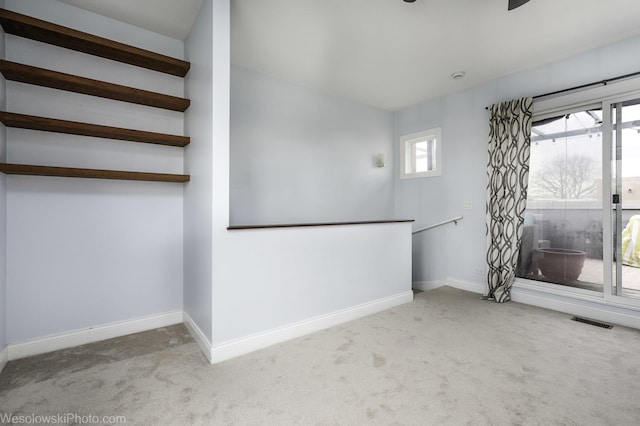 unfurnished room with carpet floors, baseboards, and visible vents