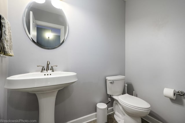 bathroom featuring a sink, toilet, and baseboards