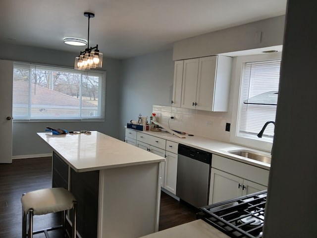 kitchen featuring tasteful backsplash, dark wood finished floors, a kitchen island, stainless steel dishwasher, and a sink