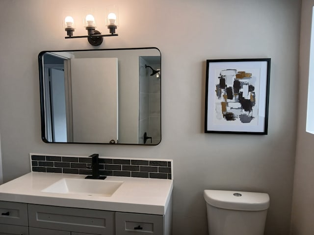 bathroom with toilet, tasteful backsplash, and vanity