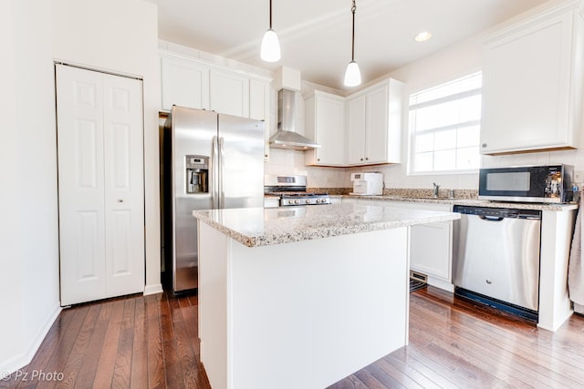 kitchen featuring white cabinetry, wall chimney exhaust hood, dark wood-style flooring, and appliances with stainless steel finishes