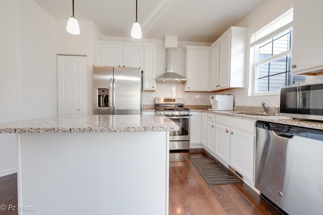 kitchen with a center island, appliances with stainless steel finishes, dark wood-style floors, white cabinetry, and wall chimney exhaust hood