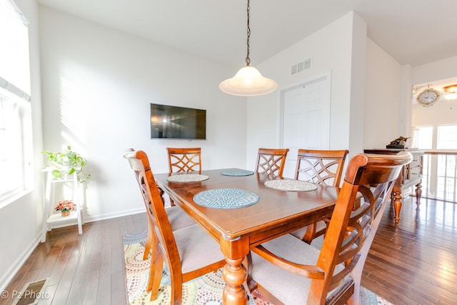 dining space featuring hardwood / wood-style floors, baseboards, and visible vents