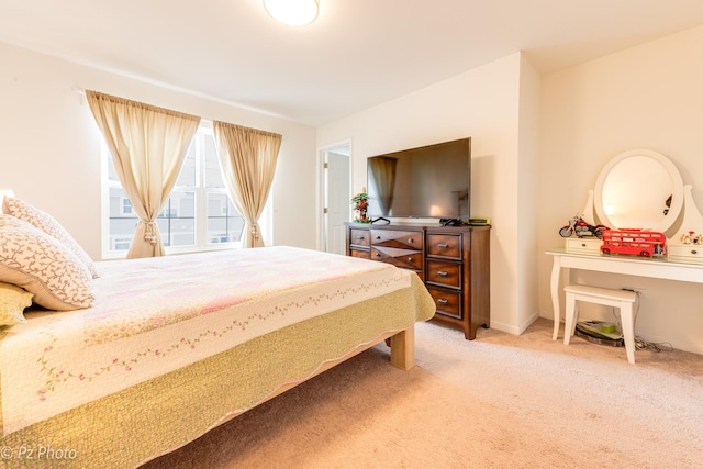 bedroom featuring light carpet and baseboards