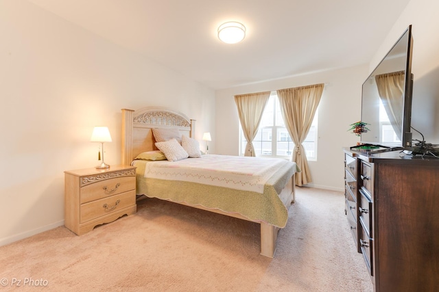 bedroom with baseboards and light carpet