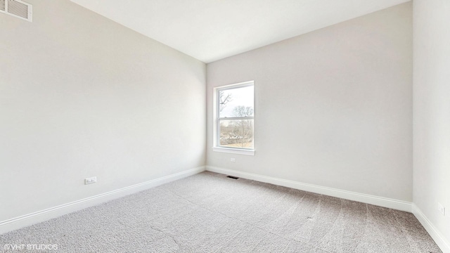 unfurnished room with carpet, visible vents, and baseboards