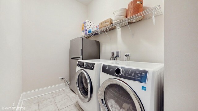 laundry area featuring laundry area, light tile patterned floors, separate washer and dryer, and baseboards