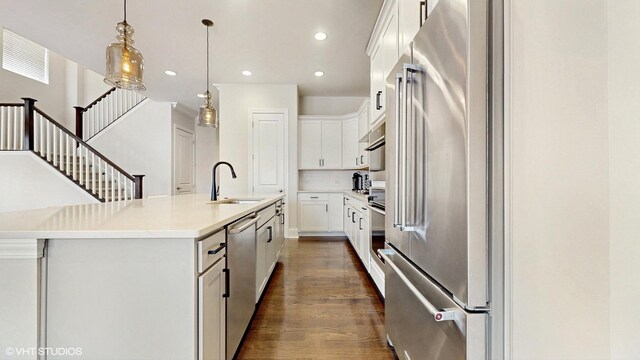 kitchen with recessed lighting, dark wood-style flooring, a sink, white cabinets, and appliances with stainless steel finishes