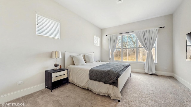 bedroom with baseboards and light colored carpet