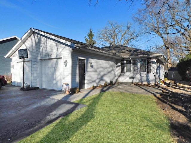 exterior space with a garage, aphalt driveway, and a front lawn