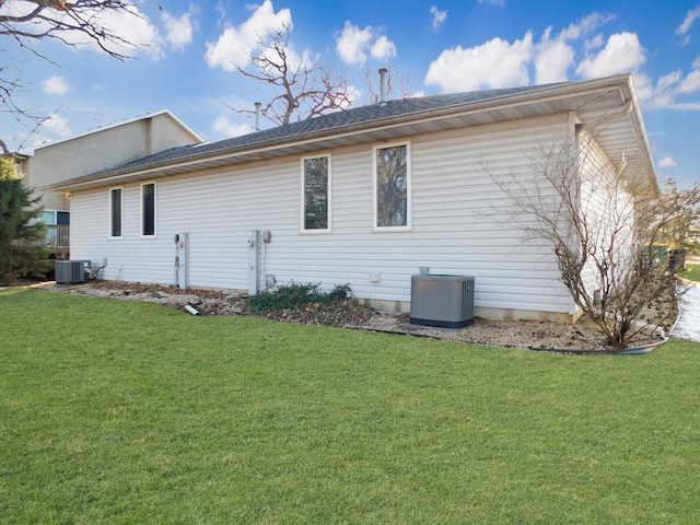 exterior space featuring central AC unit and a lawn