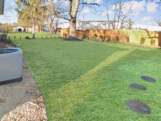 view of yard with fence and central air condition unit