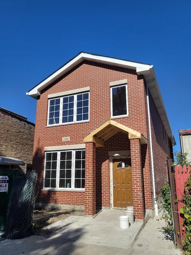 traditional home with brick siding and fence