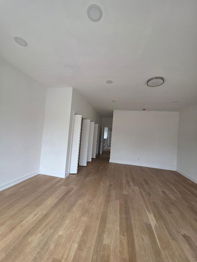 unfurnished living room with baseboards and wood finished floors