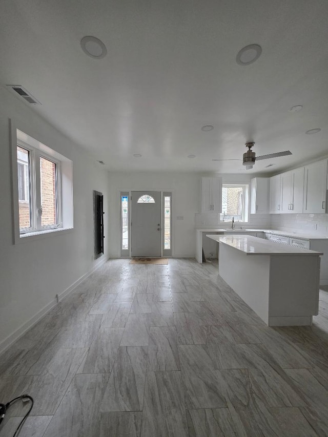 foyer entrance with baseboards and visible vents