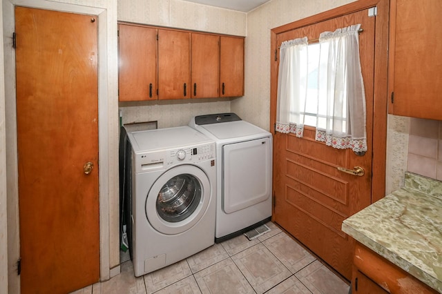 laundry area with washer and dryer, light tile patterned floors, and cabinet space