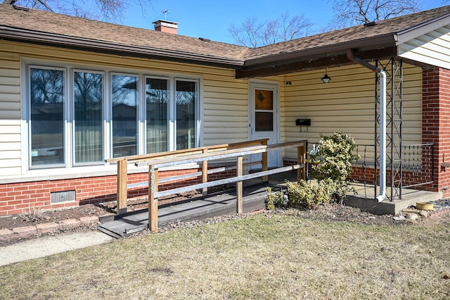 entrance to property featuring brick siding and a chimney