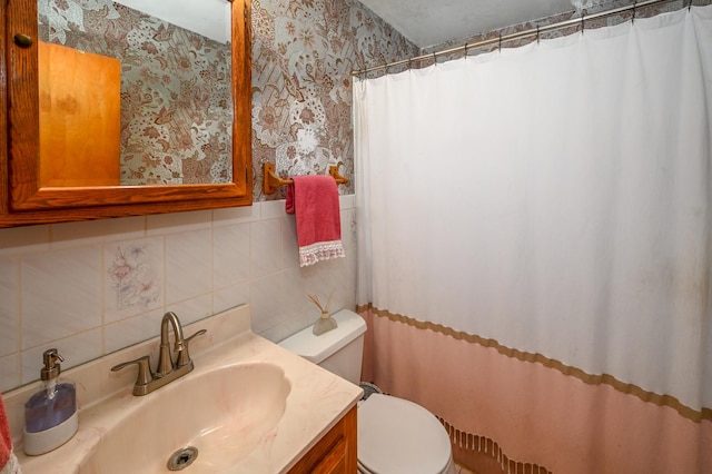 bathroom featuring vanity, wallpapered walls, curtained shower, toilet, and tasteful backsplash