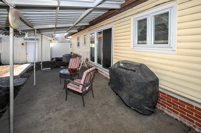 view of patio featuring a grill, central AC, a pergola, and fence