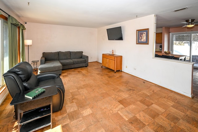 living room with visible vents and a ceiling fan