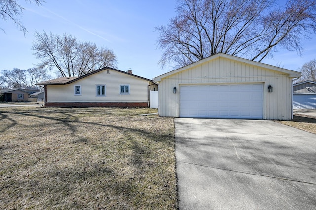 view of property exterior with a detached garage and an outdoor structure