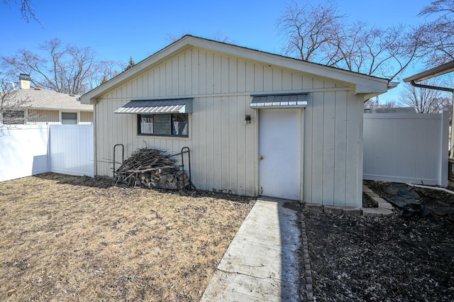 view of outbuilding featuring fence